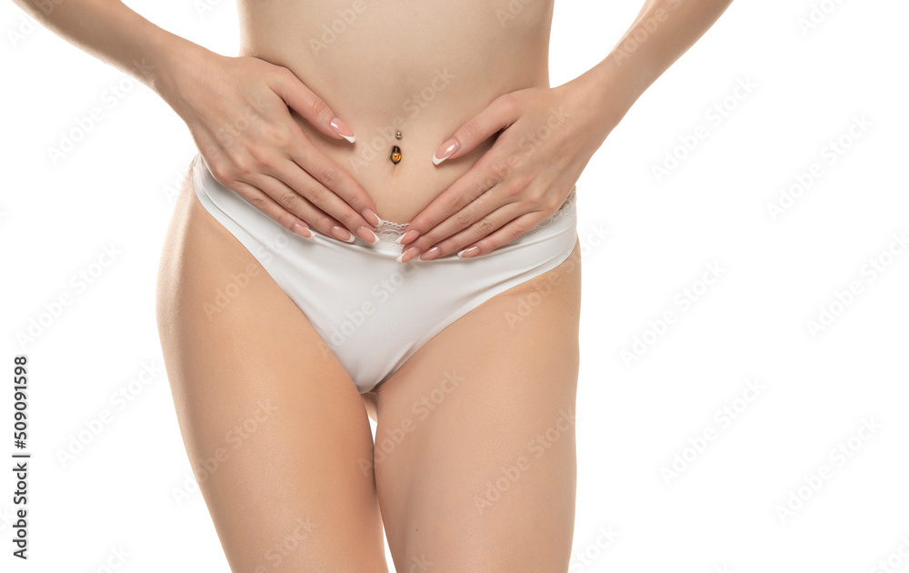 Concept of bodycare gynecology and woman's health. Cropped close up photo of woman's hand touching lower part of her abdomen, isolated on white studio background