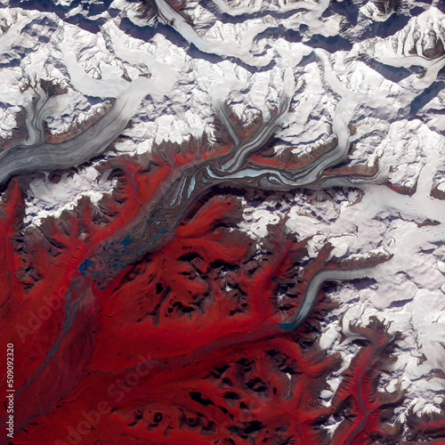 Red and white marbled surface of Susitna Glacier, Alaska, top view of ice texture, red vegetation land landscape, white snow tops, aerial photo of icebergs. Elements of this image furnished by NASA. photo