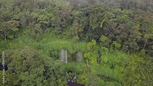 Powerful Waterfall in Tropical Jungle. 
Breathtaking aerial view flight panorama overview drone footage Benang Kelambu Lombok Indonesia 2017. Cinematic view from above Tourist Guide by Philipp Marnitz photo