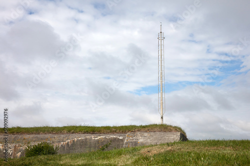 Old communication or radar tower on top of a ww2 bunker