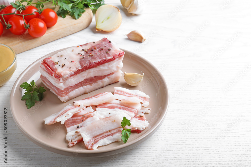 Tasty salt pork with parsley on white wooden table, space for text