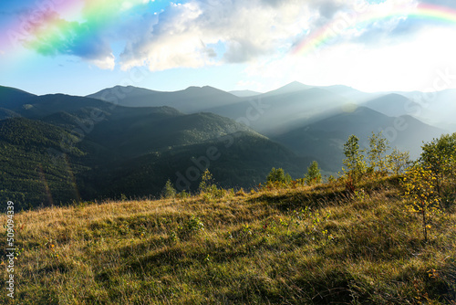 Picturesque mountain landscape and beautiful rainbow in sky