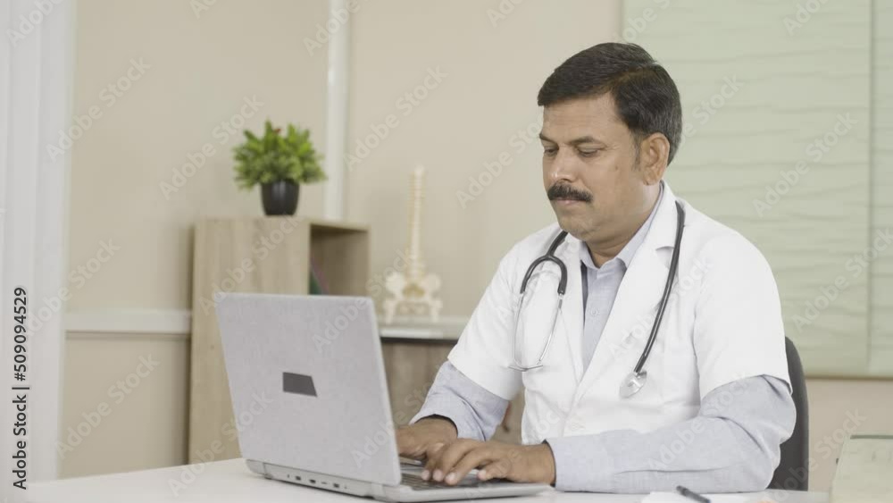 doctor at hospital seriously analysing patient reports on laptop at hospital - concept technology, workplace and occupation doctor at hospital seriously analysing patient reports on laptop at hospital - concept technology, workplace and occupation
