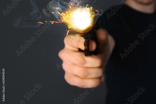 Man shooting handgun on grey background, closeup