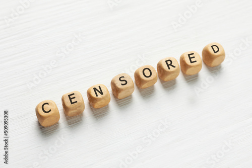 Wooden cubes with word Censored on white table