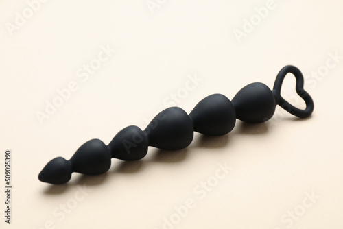 Anal beads on beige background. Sex toy