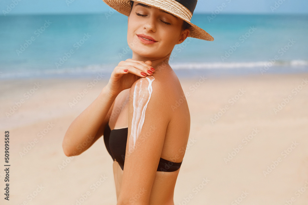 Woman Applying Sun Cream Creme on Tanned  Shoulder . Sun Protection. Skin Care. Girl Using Sunscreen to Skin. Portrait Of Female Holding Suntan Lotion and Moisturizing Sunblock.