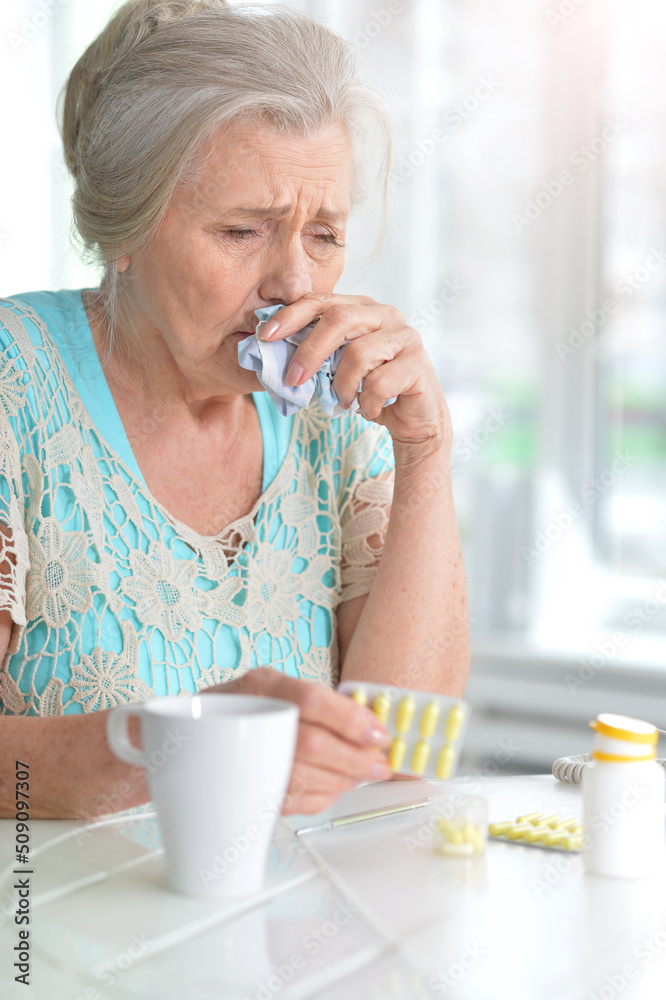 Sick elderly woman with pills