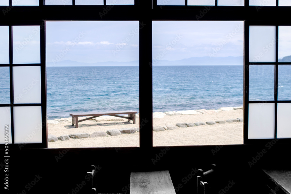 窓越しの海とベンチ