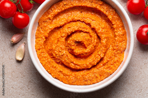 Salsa Romesco. Tomato-based Spanish vegetable sauce. Made from mixture of roasted tomatoes, roasted red bell peppers and garlic, toasted almonds, olive oil and bread. Close-up. photo