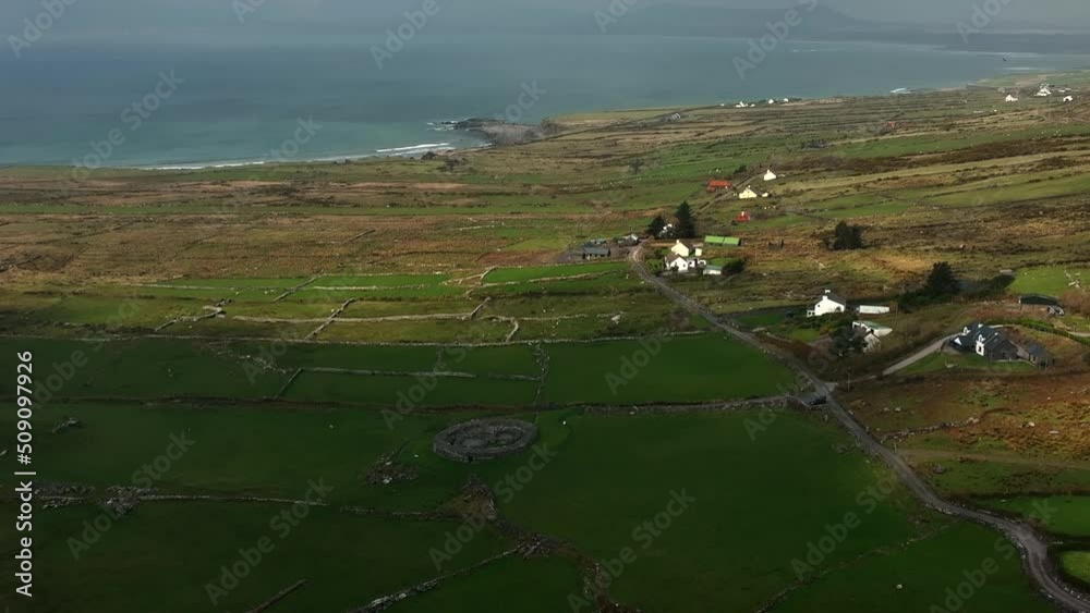 Loher Ringfort, Kerry, Ireland, March 2022. Drone orbits the ancient monument from the southeast ascending to a higher altitude revealing Ballinskelligs Bay and the Atlantic Ocean in the distance. Loher Ringfort, Kerry, Ireland, March 2022. Drone orbits the ancient monument from the southeast ascending to a higher altitude revealing Ballinskelligs Bay and the Atlantic Ocean in the distance.
