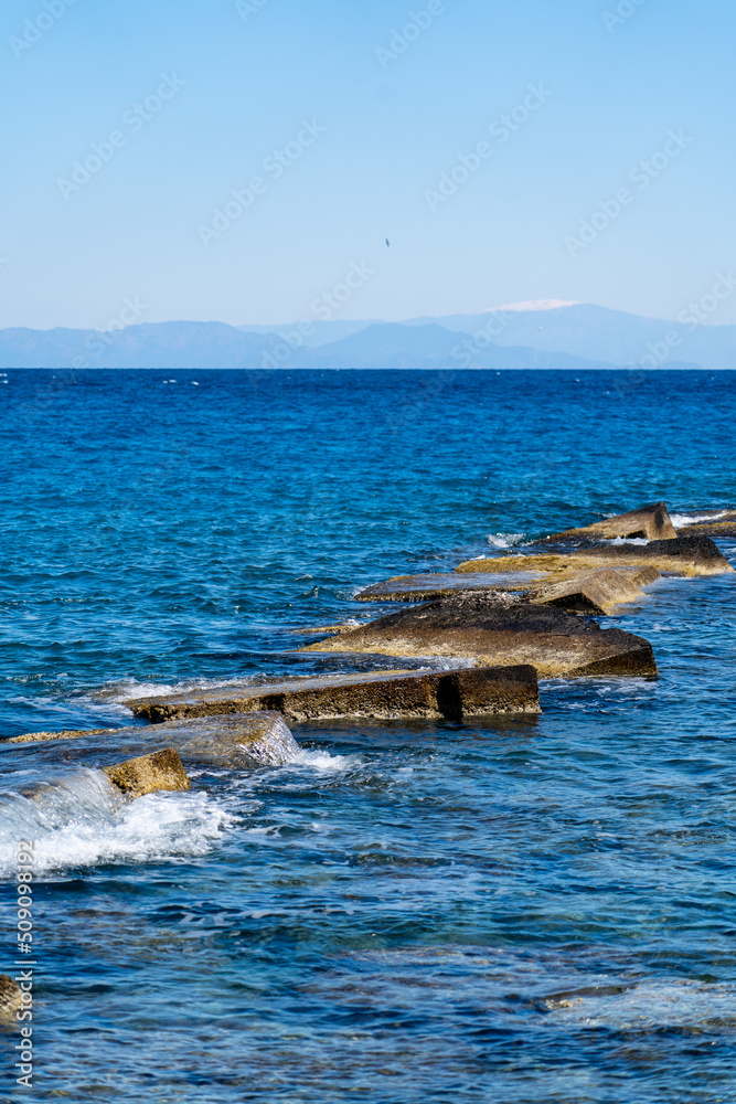 Old stone bares and large rocks made a barrier in the beach for ...
