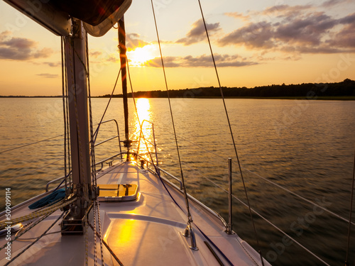 Fototapeta Naklejka Na Ścianę i Meble -  sailing yacht bow in sunset light, sailing on a lake