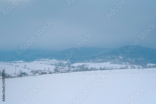 Snowing landscape in Europe. Lonely small village before the storm at mountains © yarohork
