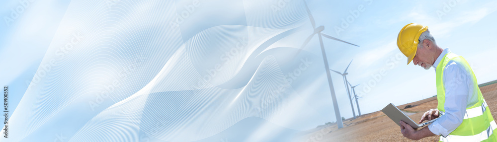 Engineer using laptop for wind turbine inspection; panoramic banner Engineer using laptop for wind turbine inspection; panoramic banner