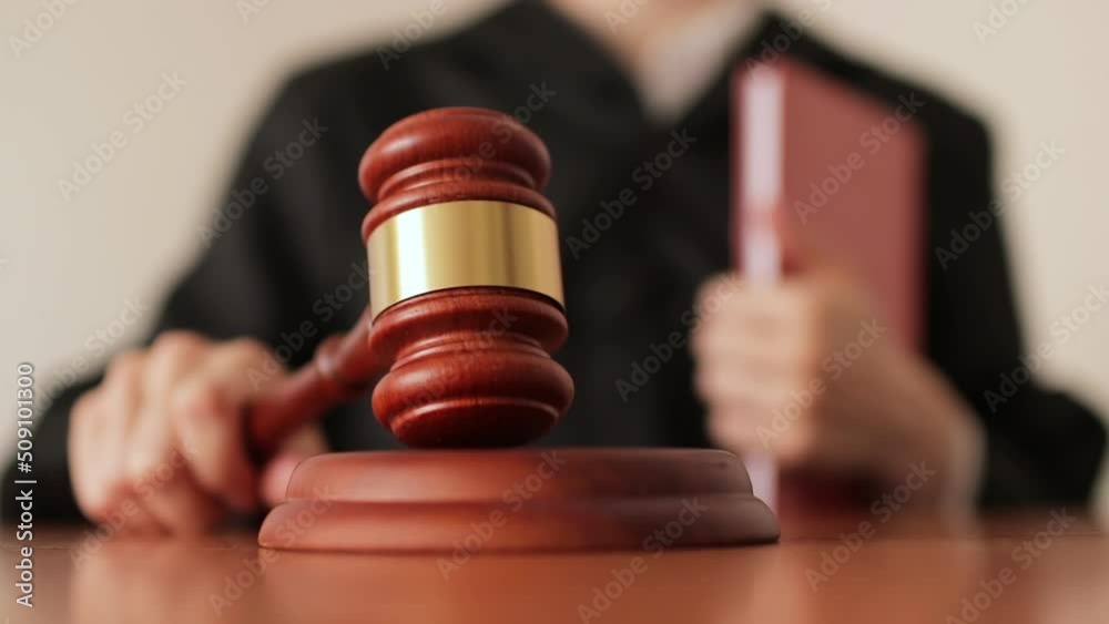 Judge's hand banging a gavel in a courtroom close up