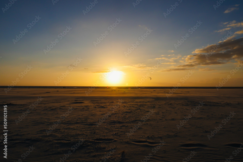Sunset on beach with scenic sky in horizon over water