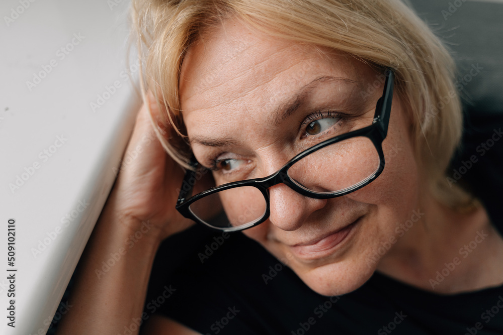 Authentic happy portrait of mature blonde woman with toothy smile ay home Authentic happy portrait of mature blonde woman with toothy smile ay home