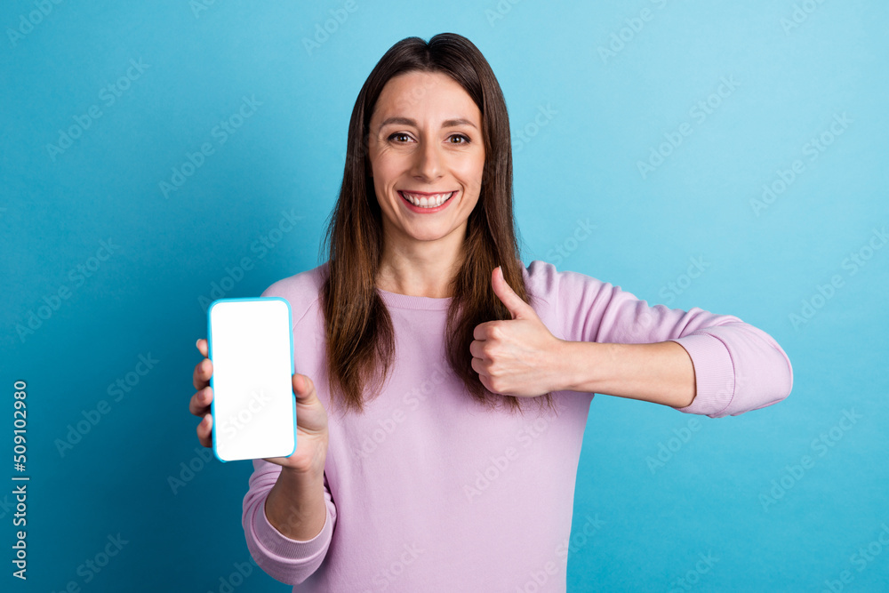 Fototapeta premium Photo of young lady present show thumb-up feedback suggest mobile device web nomad isolated over blue color background