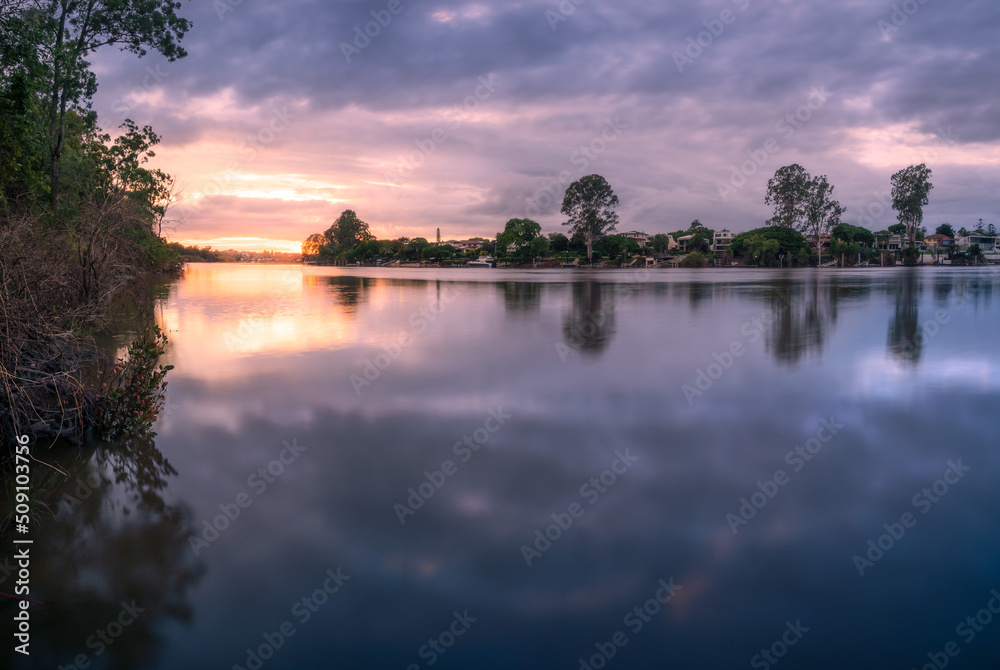 Obraz premium riverside sunrise with cloud reflections