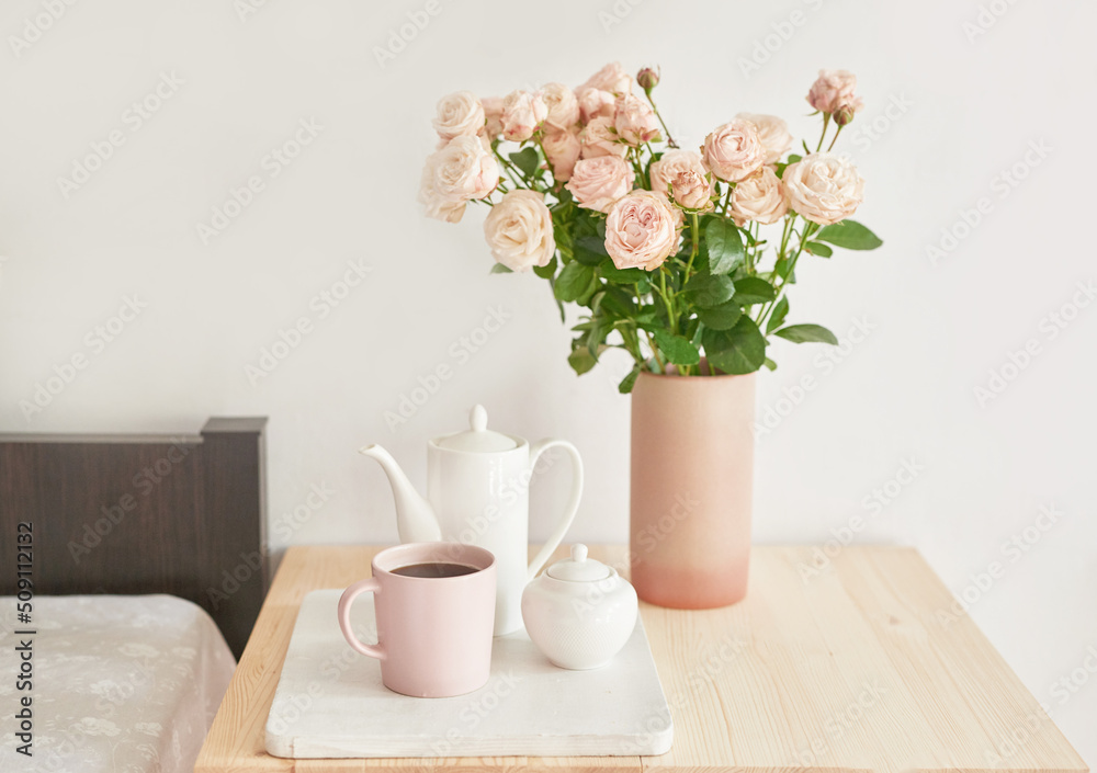 Good cozy morning. Bouquet of rose flowers in vase on table. Hotel room with bed. Check in hotel. Rest and relaxation. Coffee in bed. Romantic breakfast. Valentine's Day Good cozy morning. Bouquet of rose flowers in vase on table. Hotel room with bed. Check in hotel. Rest and relaxation. Coffee in bed. Romantic breakfast. Valentine's Day