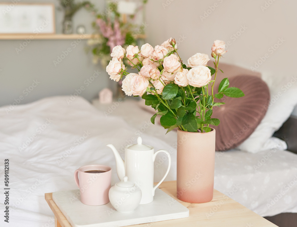 Good cozy morning. Bouquet of rose flowers in vase on table. Hotel room with bed. Check in hotel. Rest and relaxation. Coffee in bed. Romantic breakfast. Valentine's Day