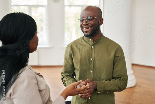 Happy young African American psychologist consulting female patient sharing her worries and troubles during psychotherapy session photo