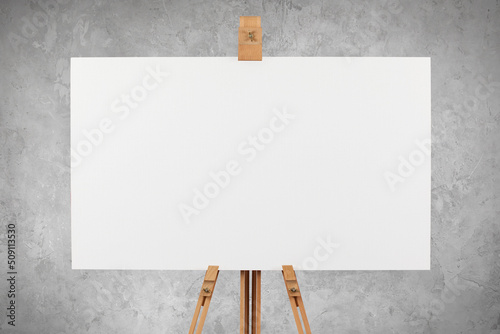 Canvas Print A blank artist's canvas on an easel against a concrete wall background