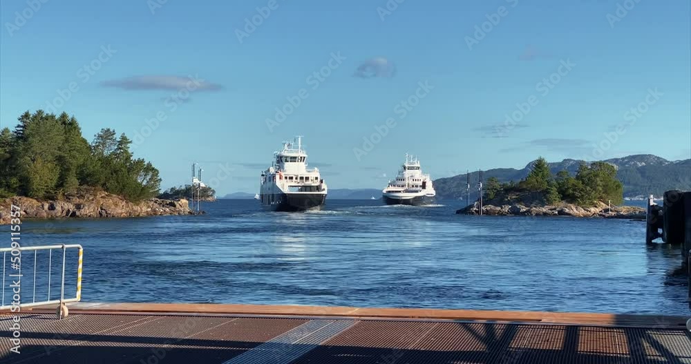 Two ferries are leaving pier in norwegian sunny landcape