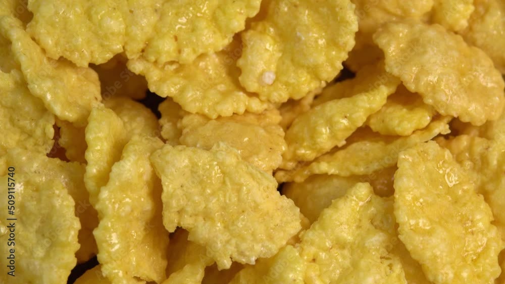 Crispy corn flakes rotating close up, dry healthy breakfast. Honey cornflakes for healthy cereal breakfast. Cooking healthy breakfast concept. High quality 4k footage Crispy corn flakes rotating close up, dry healthy breakfast. Honey cornflakes for healthy cereal breakfast. Cooking healthy breakfast concept. High quality 4k footage