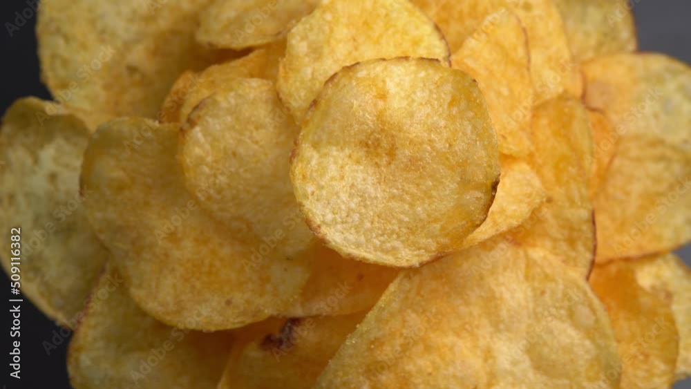 Craft crispy potato chips rotating close up. Golden fried potatoes in macro. Potato snack for unhealthy fast food. High quality 4k footage Craft crispy potato chips rotating close up. Golden fried potatoes in macro. Potato snack for unhealthy fast food. High quality 4k footage