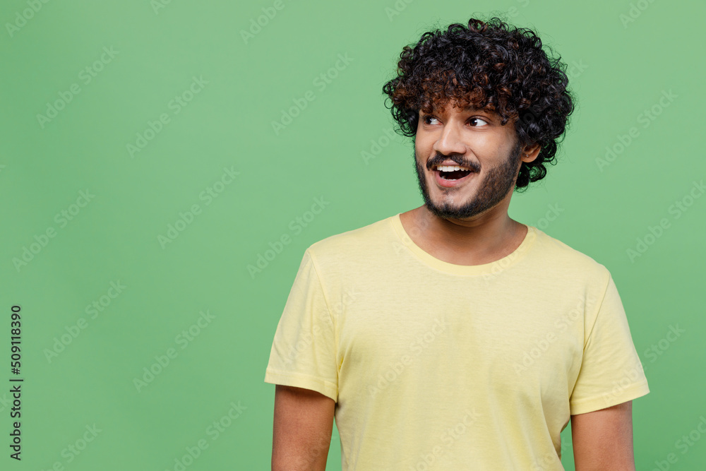 custom made wallpaper toronto digitalYoung happy amazed surprised fun Indian man 20s in basic yellow t-shirt look aside on workspace area mock up isolated on plain pastel light green background studio portrait. People lifestyle concept.