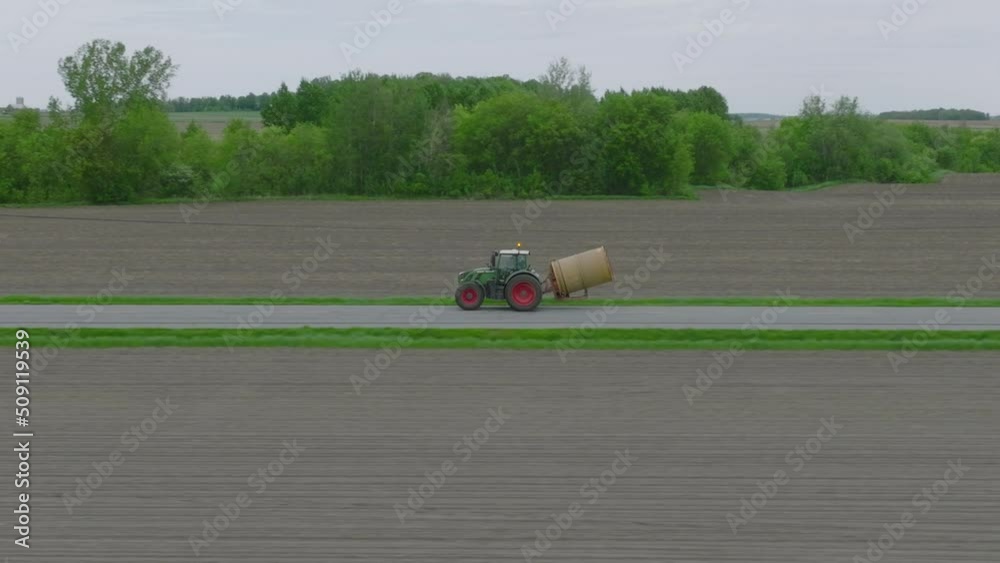 Farm Tractor Traveling On A Countryside Road. Aerial Tracking Shot Farm Tractor Traveling On A Countryside Road. Aerial Tracking Shot