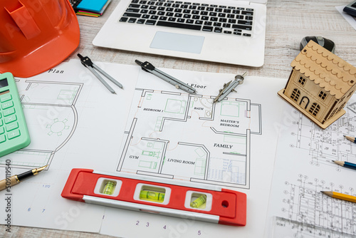 house project plan with work tools and helmet on desk