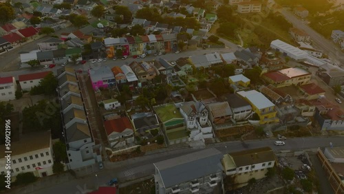 Aerial footage of residential houses along streets in urban neighbourhood at dusk. Port Elisabeth, South Africa