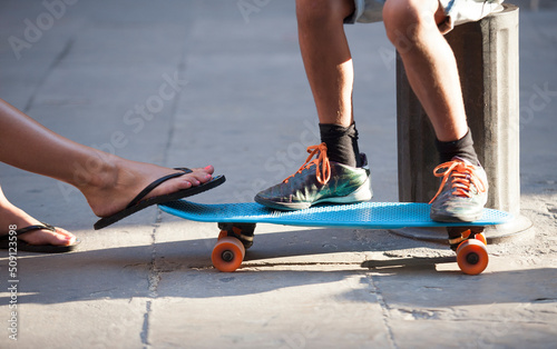 feet of man and woman on skateboard 