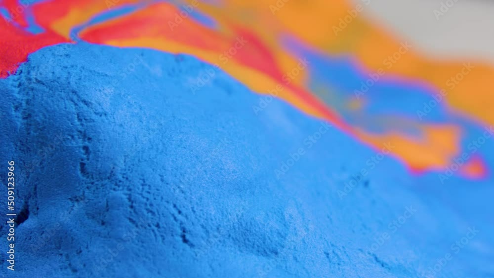 multicolored plasticine rotates close up view, vibrant abstract image red, yellow and blue.