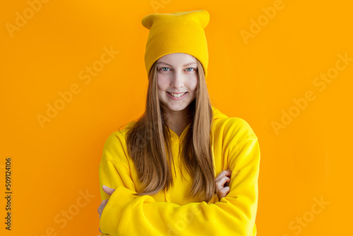 Young teen girl wearing yellow hoodie and hat, Hipster © Tatyana Gladskih