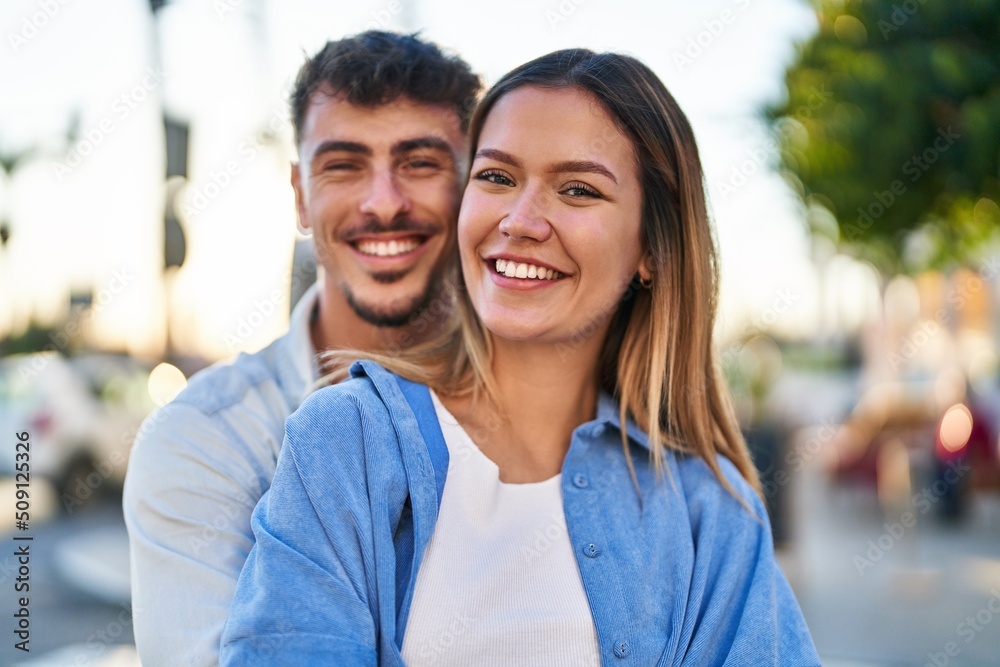 Young man and woman couple hugging each other standing at street Young man and woman couple hugging each other standing at street