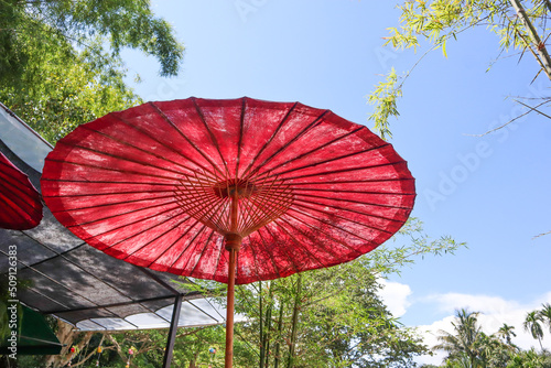 Thai original tradition red umbrella in garden   Lanna Style in Northern Thailand.