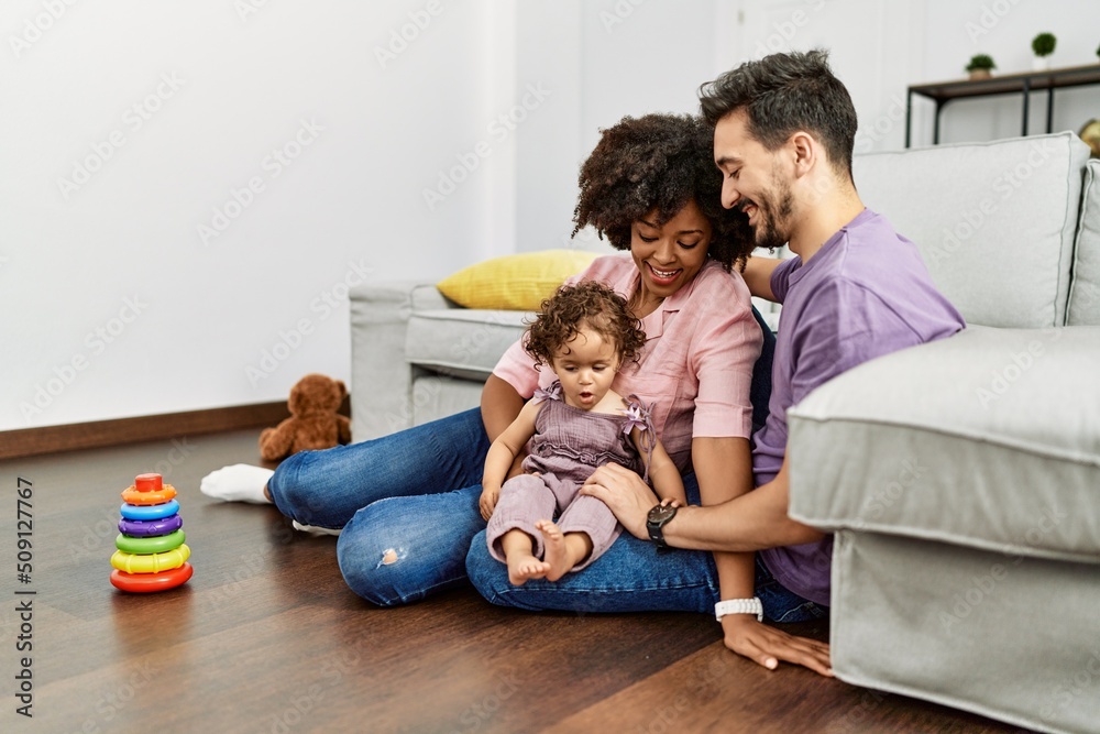 Couple and daughter smiling confident playing with toys sitting on the floor at home Couple and daughter smiling confident playing with toys sitting on the floor at home