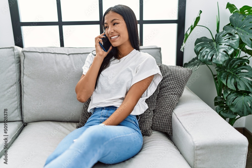 Young latin woman smiling confident talking on the smartphone at home Young latin woman smiling confident talking on the smartphone at home