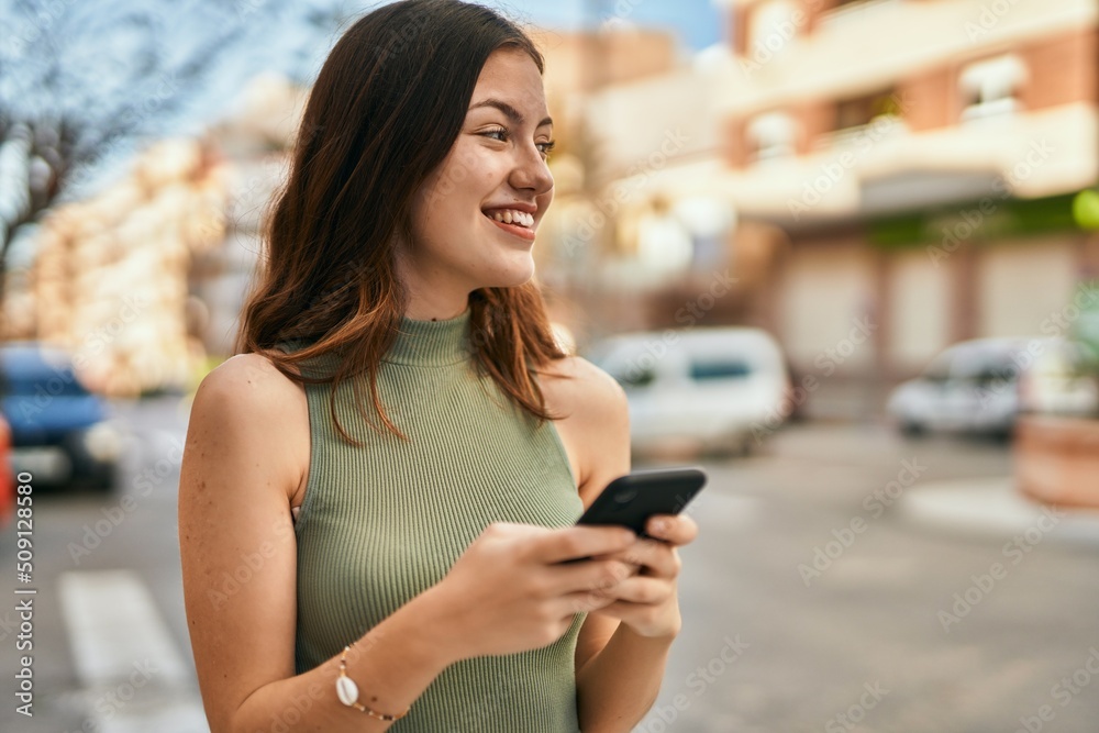 Young caucasian girl smiling happy using smartphone at the city. Young caucasian girl smiling happy using smartphone at the city.
