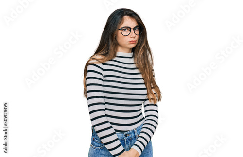 Young beautiful teen girl wearing casual clothes and glasses skeptic and nervous, frowning upset because of problem. negative person.