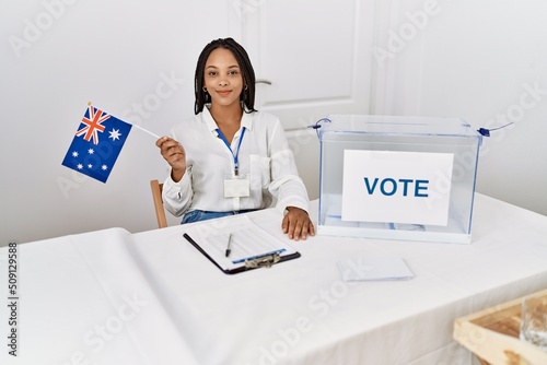 Young african american woman smiling confident holding australia flag working at electoral college