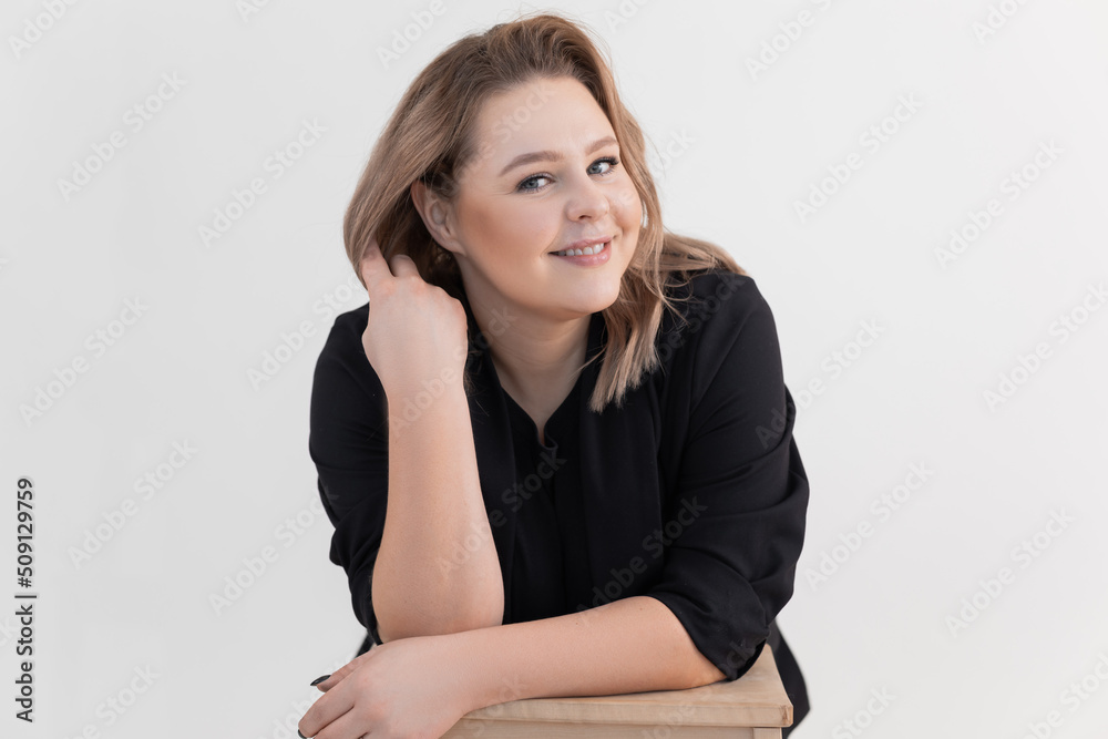 Studio shot of smiling and friendly elegant blond woman touching hairstyle. Charming professional make up and haircut Studio shot of smiling and friendly elegant blond woman touching hairstyle. Charming professional make up and haircut