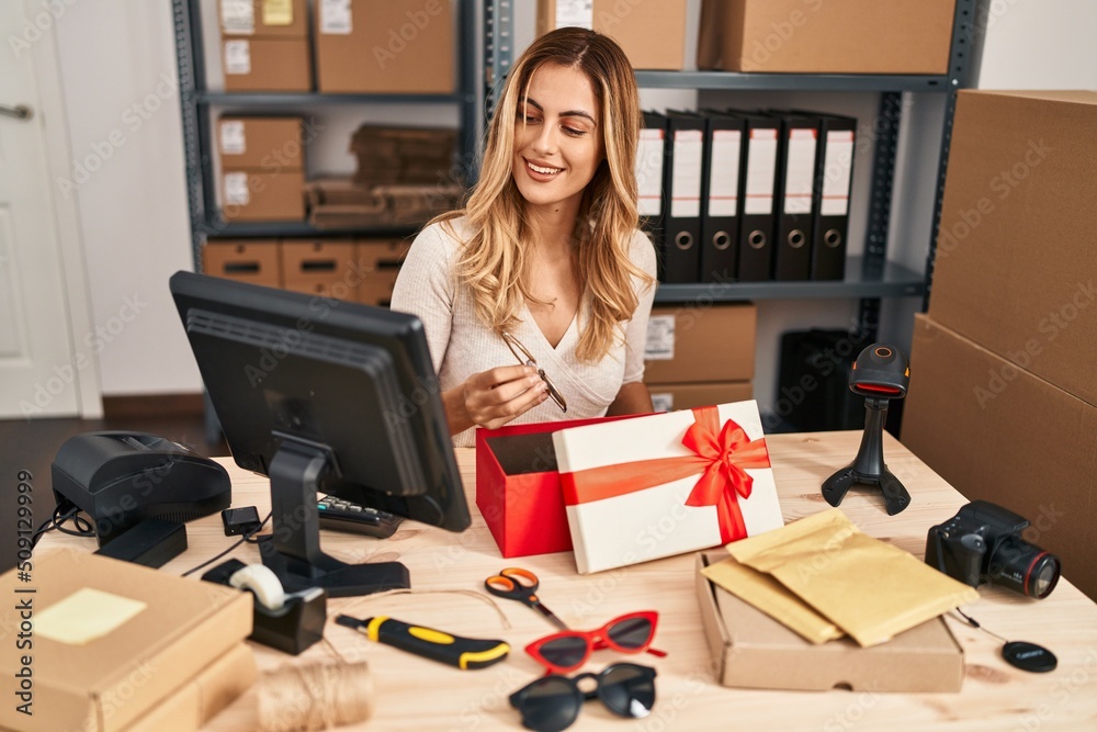 Young blonde woman ecommerce business worker packing sunglasses gift at office