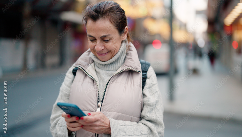 Middle age hispanic woman smiling confident using smartphone at street Middle age hispanic woman smiling confident using smartphone at street