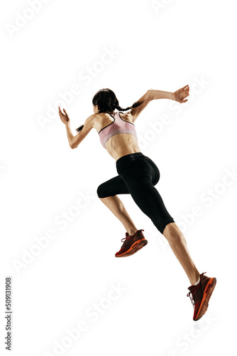 Rear view of young caucasian woman running isolated on white studio background. One female runner or jogger. Sport, track-and-field athletics, competition concept
