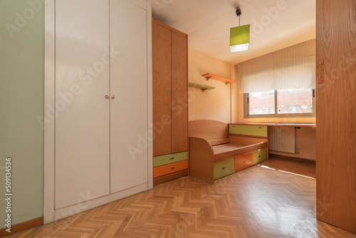 Youth bedroom with pine wood furniture with matching shelves  desk and cabinets  one matching and one white built into the wall